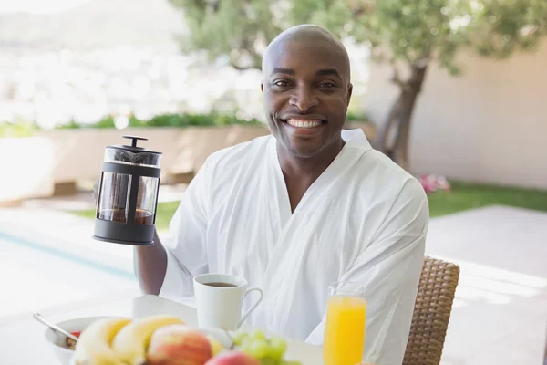 Handsome man in bathrobe having breakfast outside — Stock Photo, Image