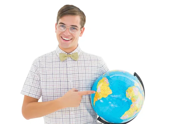 Geeky hipster segurando um globo sorrindo para a câmera — Fotografia de Stock