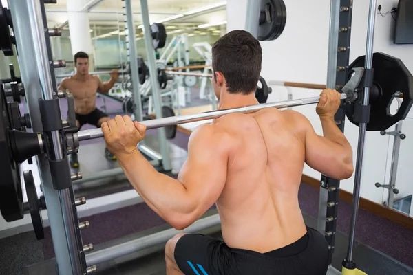 Hombre musculoso sin camisa levantando barra en el gimnasio —  Fotos de Stock