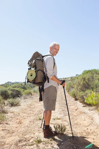 Handsome hiker smiling at camera in the countryside — Stock Photo, Image
