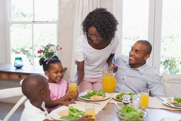 Mãe servindo suco para sua família no almoço — Fotografia de Stock