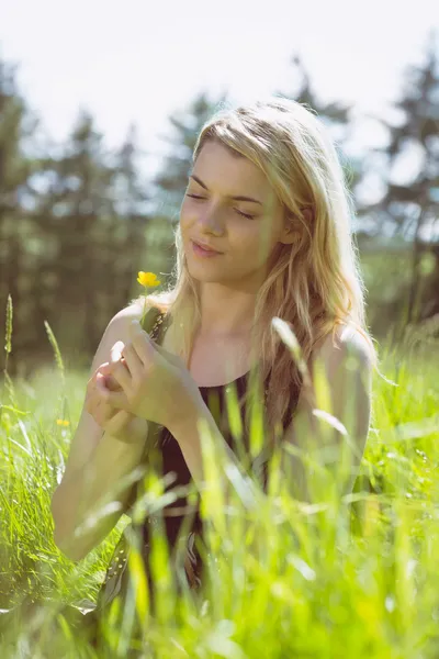 Loira bonita em sundress segurando flor amarela — Fotografia de Stock