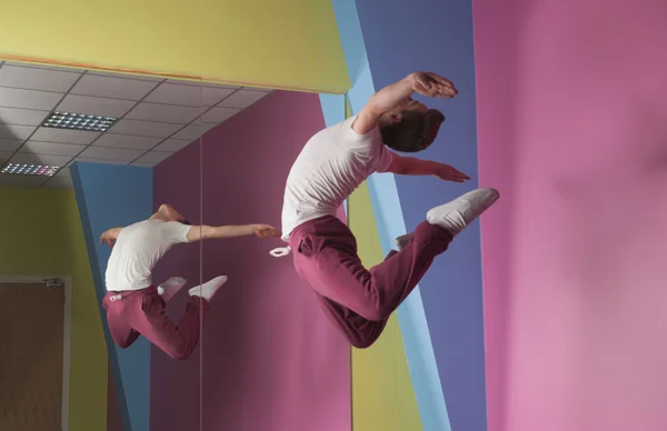 Cool break dancer mid air in front of mirror — Stock Photo, Image