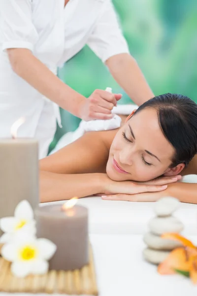 Brünette genießt Kräuterkompresse Massage — Stockfoto