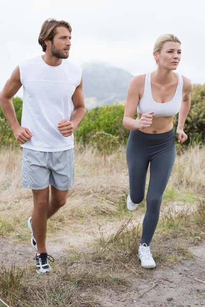 Coppia jogging sul sentiero di montagna — Foto Stock