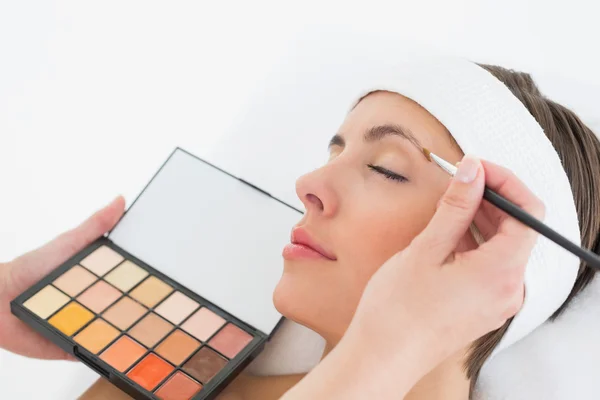 Hand applying eyeshadow to beautiful woman — Stock Photo, Image