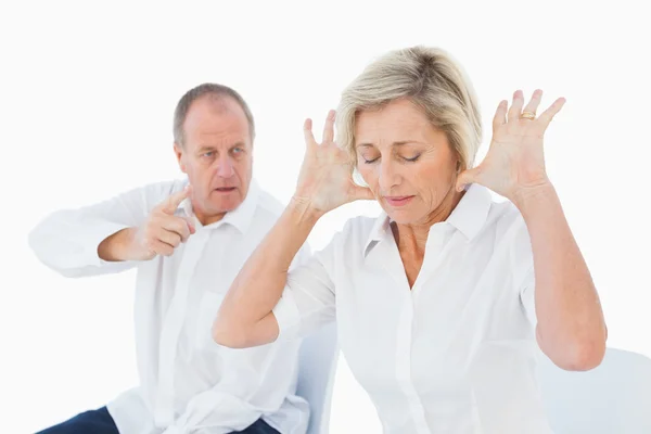 Older couple sitting in chairs arguing — Stock Photo, Image