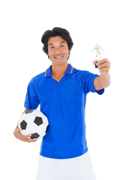 Jogador de futebol em azul segurando vencedores troféu — Fotografia de Stock