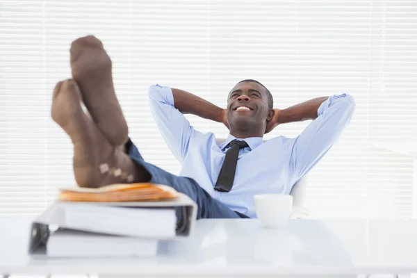 Entspannter Geschäftsmann sitzt mit erhobenen Füßen im Stuhl — Stockfoto