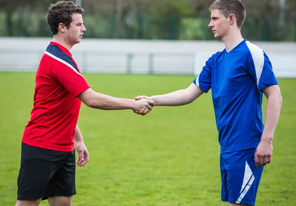 Jugadores de fútbol en azul y rojo estrechando las manos —  Fotos de Stock