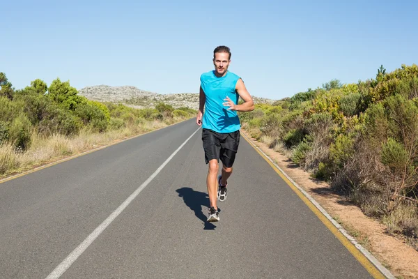 Hombre en forma trotando en el camino abierto —  Fotos de Stock