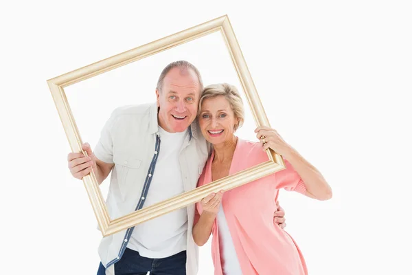 Ouder koppel glimlachen op camera via afbeeldingsframe — Stockfoto