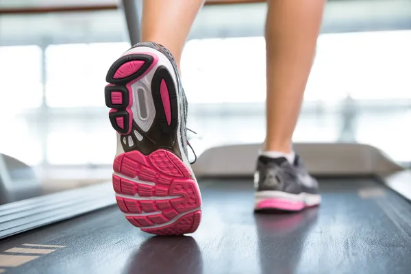 Piedi delle donne in esecuzione sul tapis roulant — Foto Stock