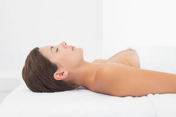Vacker kvinna ligga på massagebänk på spacenter — Stockfoto