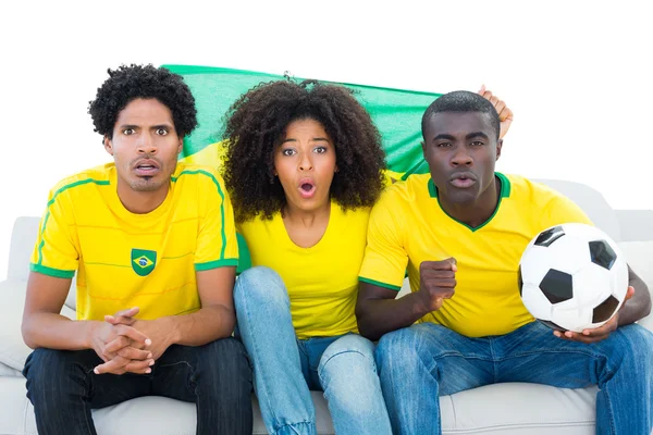 Glada fotbollsfans i gult med Brasilien flagga — Stockfoto