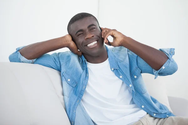 Casual man zit op de Bank op de telefoon — Stockfoto