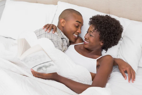 Pareja feliz acostada en la cama abrazándose — Foto de Stock