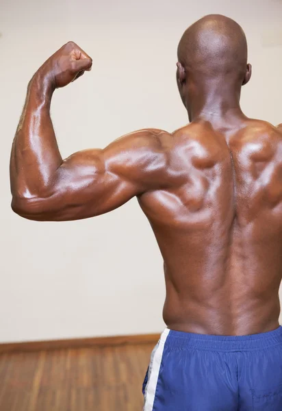 Vista posteriore dell'uomo muscoloso senza camicia che flette i muscoli — Foto Stock