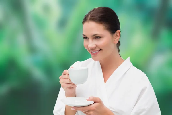 Beautiful brunette in bathrobe drinking herbal tea — Stock Photo, Image