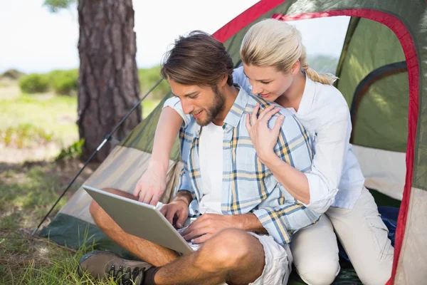 Paar zitten door hun tent met behulp van laptop — Stockfoto