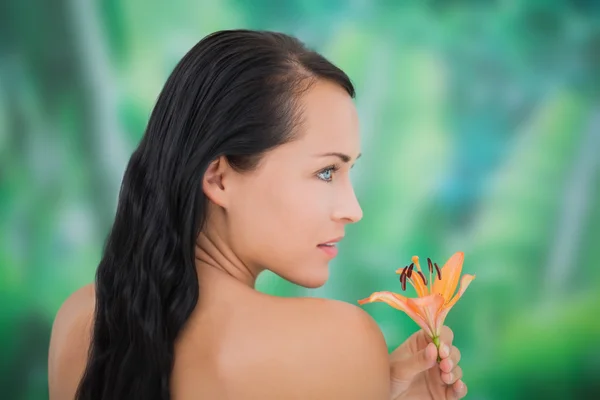 Beautiful nude brunette smelling lily — Stock Photo, Image