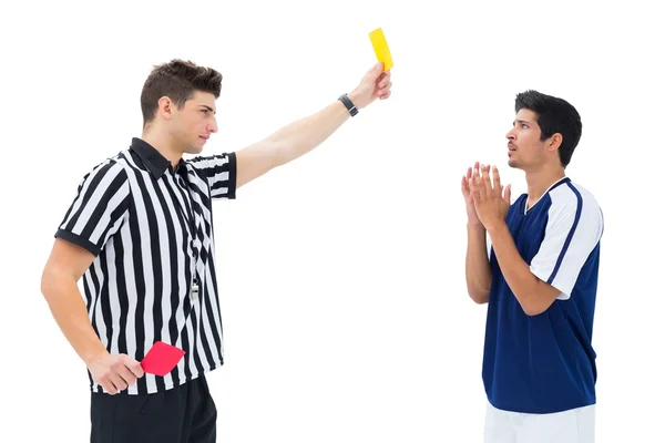 Судья показывает футболисту желтую карточку — стоковое фото