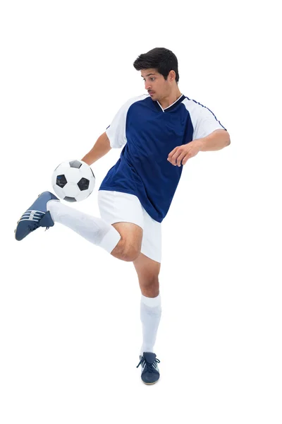 Fotbalista v modrém kopající míč — Stock fotografie