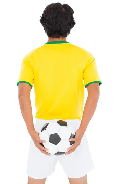 Jugador de fútbol en pelota amarilla — Foto de Stock