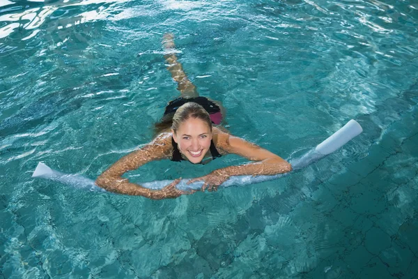 Blondine schwimmt mit Schaumstoffrolle — Stockfoto