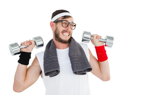 Geeky hipster lifting dumbbells in sportswear — Stock Photo, Image