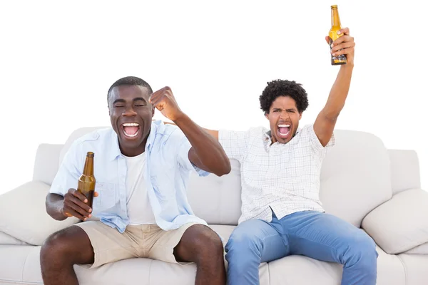 Ventiladores de esportes extáticos sentados no sofá com cervejas — Fotografia de Stock