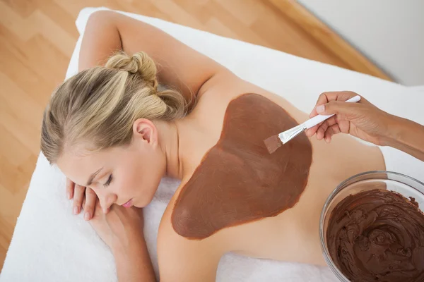 Schöne Blondine genießt eine Schönheitsbehandlung mit Schokolade — Stockfoto