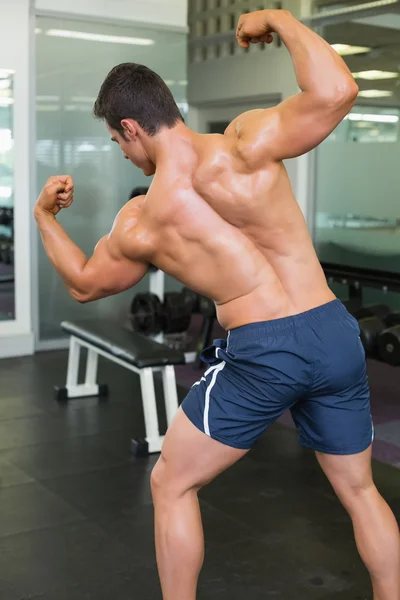 Vista posteriore di un uomo muscolare che flette i muscoli — Foto Stock