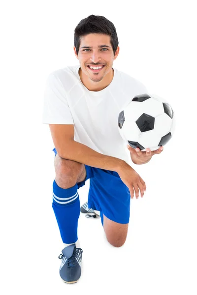 Joueur de football en bleu agenouillé avec balle — Photo