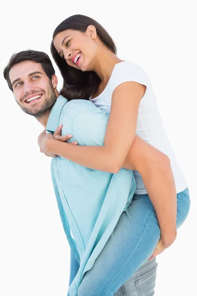 Happy casual man giving pretty girlfriend piggy back — Stock Photo, Image