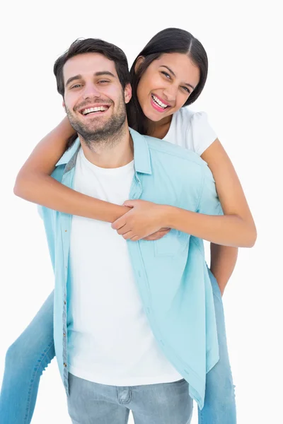 Happy casual man giving pretty girlfriend piggy back — Stock Photo, Image