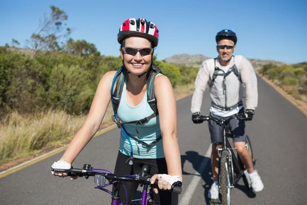 Fit happy couple going for a bike ride in the countryside — Stock Photo, Image