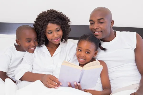 Happy family reading book together — Stock Photo, Image