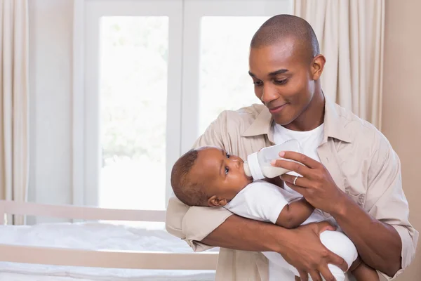 Happy father feeding his baby boy a bottle — Stock Photo, Image
