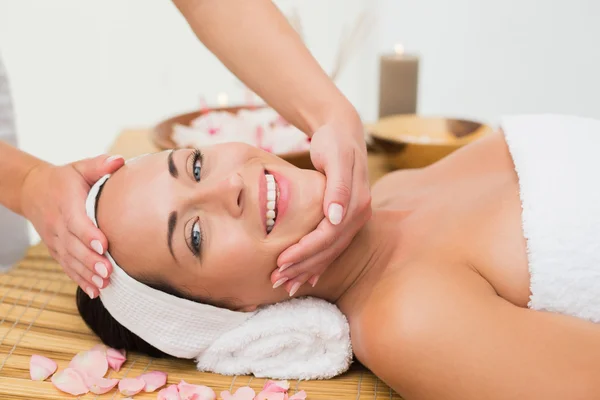 Peaceful brunette enjoying a face massage Royalty Free Stock Images