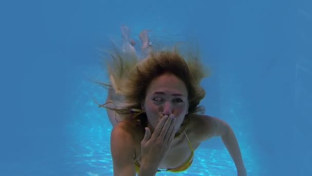 Blonde swimming blowing kiss — Stock Video