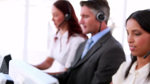 Callcenter-Agenten arbeiten und sprechen über Headsets — Stockvideo