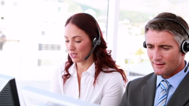 Agentes del centro de llamadas trabajando y hablando con auriculares — Vídeos de Stock