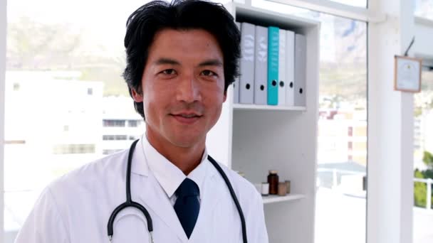 Guapo joven médico sonriendo a la cámara — Vídeos de Stock