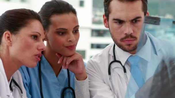 Equipo médico mirando rayos X juntos — Vídeos de Stock