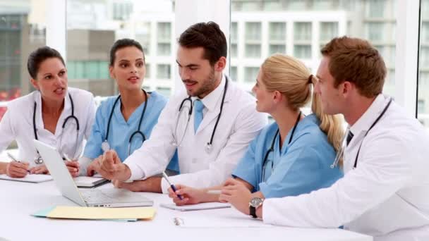 Équipe médicale regardant ordinateur portable pendant la réunion — Video