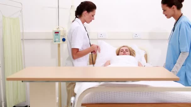 Medical team checking on sick patient in bed — Stock Video