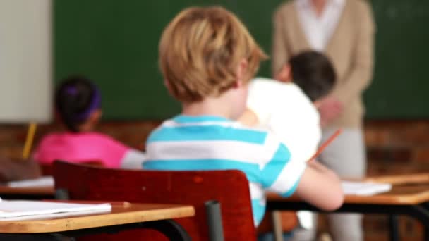 Petite fille colorant dans la salle de classe et souriant à la caméra — Video