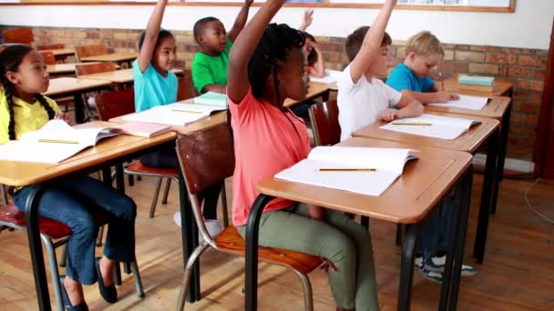 Öğrencilerin sınıf sırasında ellerini yükselterek — Stok video