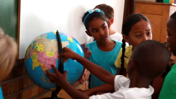 Pupils looking at the globe in classroom — Stock Video